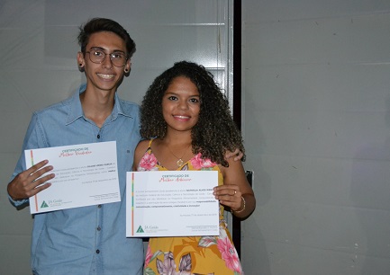 Os miniempresários Gilmar e Nathália após receber certificações pelo melhor desempenho como vendedor e adviser, respectivamente