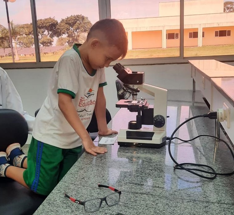 Aluno da Escola Manoel Theodoro observando microrganismos no lab. de Biologia