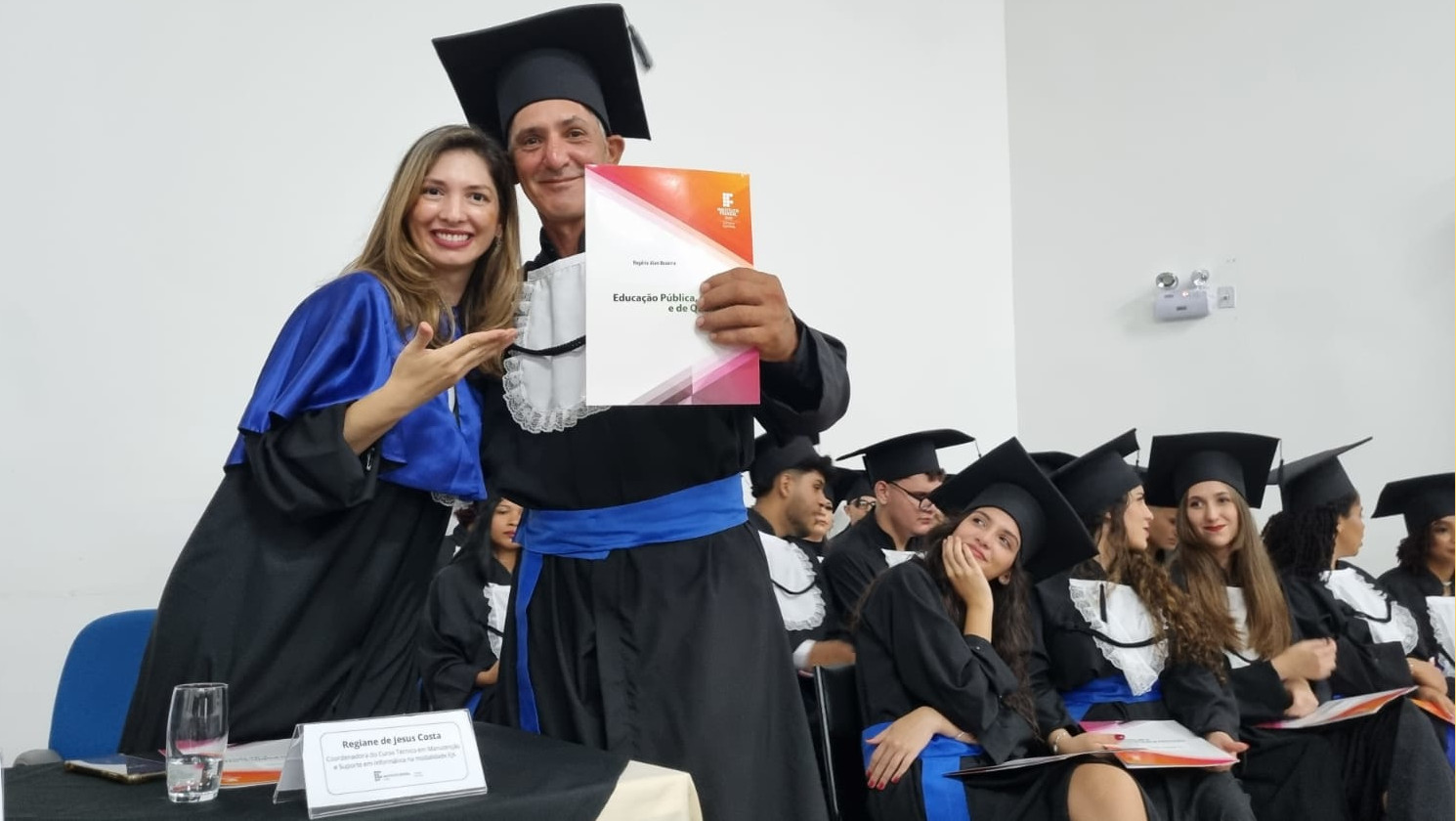 Coordenadora Rejane Costa entrega certificado ao formando da EJA-Informática, Rogério Alan Bezerra