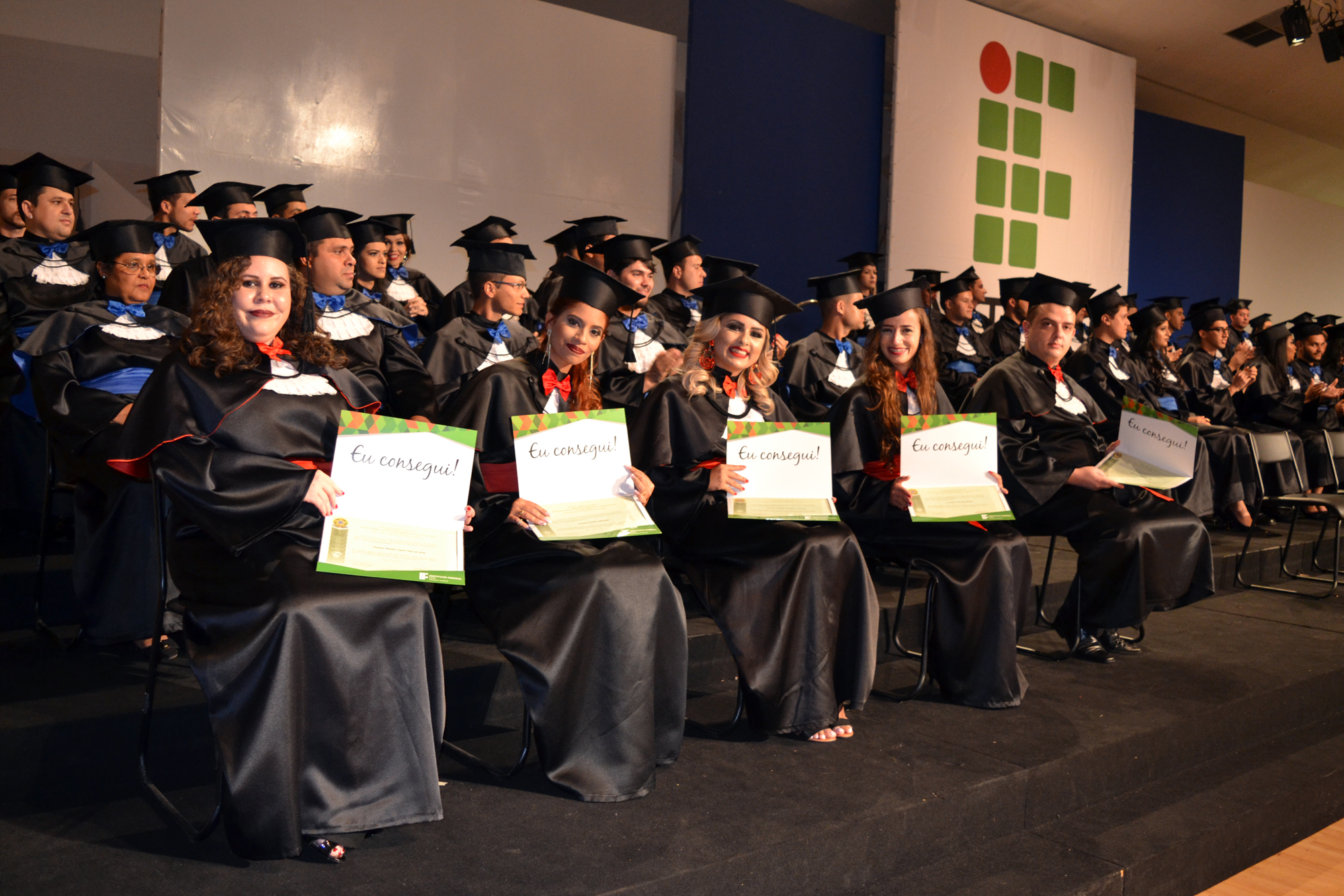 Formandos exibem diplomas recebidos durante a cerimônia de colação de grau.