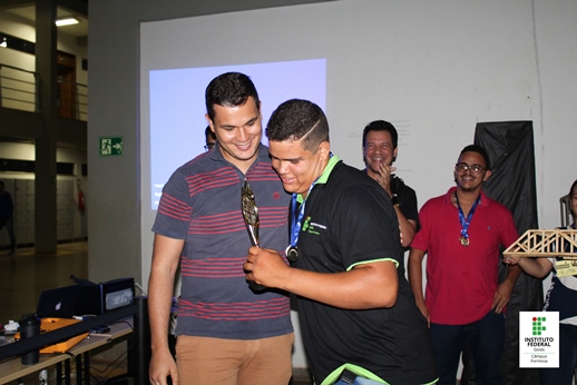 O aluno de Edificações, Vinicius Luiz de Moraes, levanta o troféu Campeão Geral, entregue pelo diretor-geral Murilo de Assis Silva